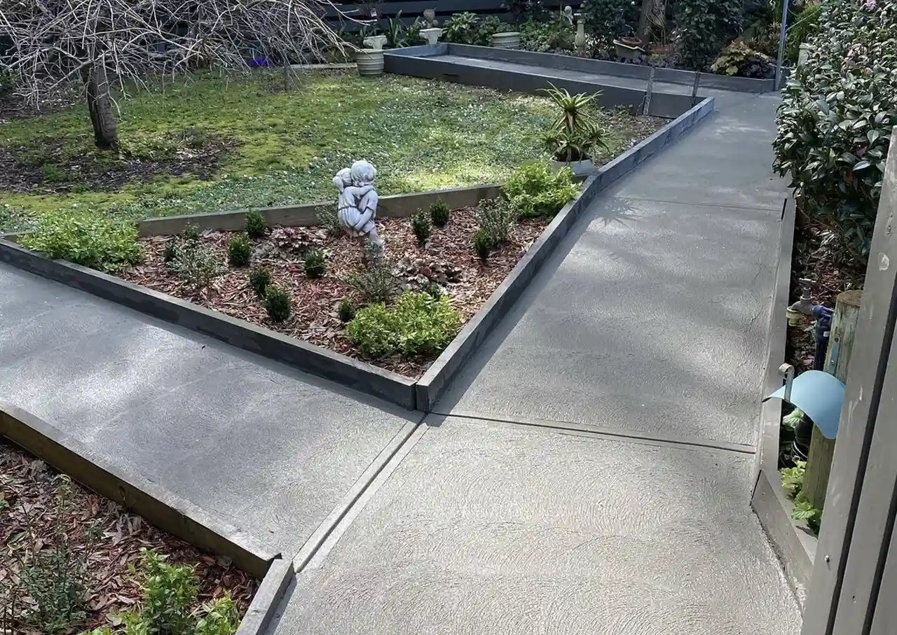 A house with plain concrete garden pathways. | DigKing